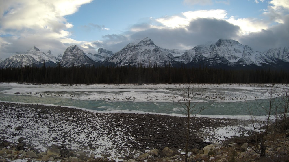 snow covered mountains under cloudy sky