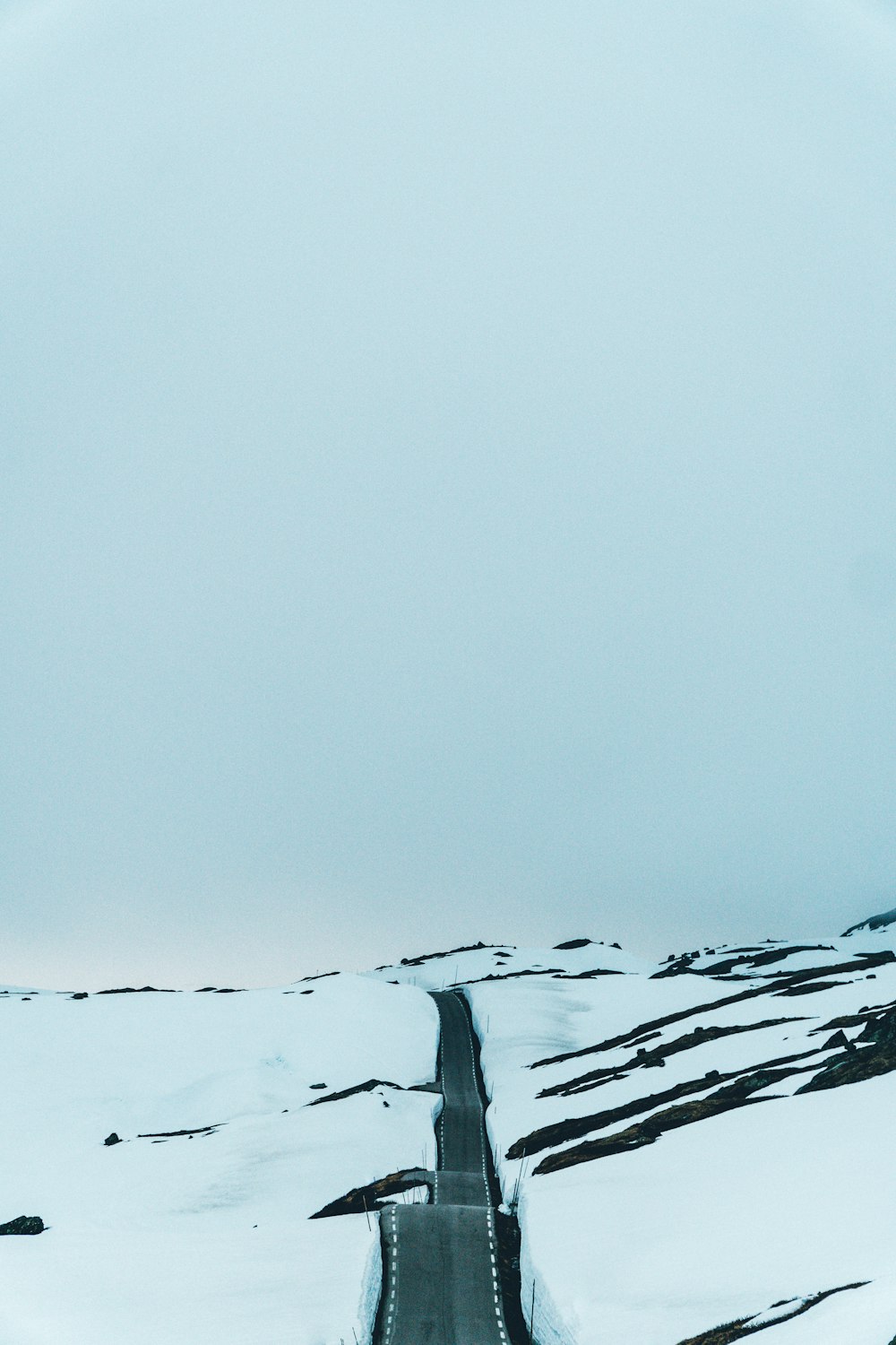 curved road between snow capped land