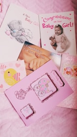 A collection of colorful greeting cards celebrating the birth of a baby girl. The cards feature messages like 'Congratulations on your Baby Girl!' and images of cute designs, including a teddy bear and a baby. The overall theme is joyful and celebratory, with elements like strollers and hearts.