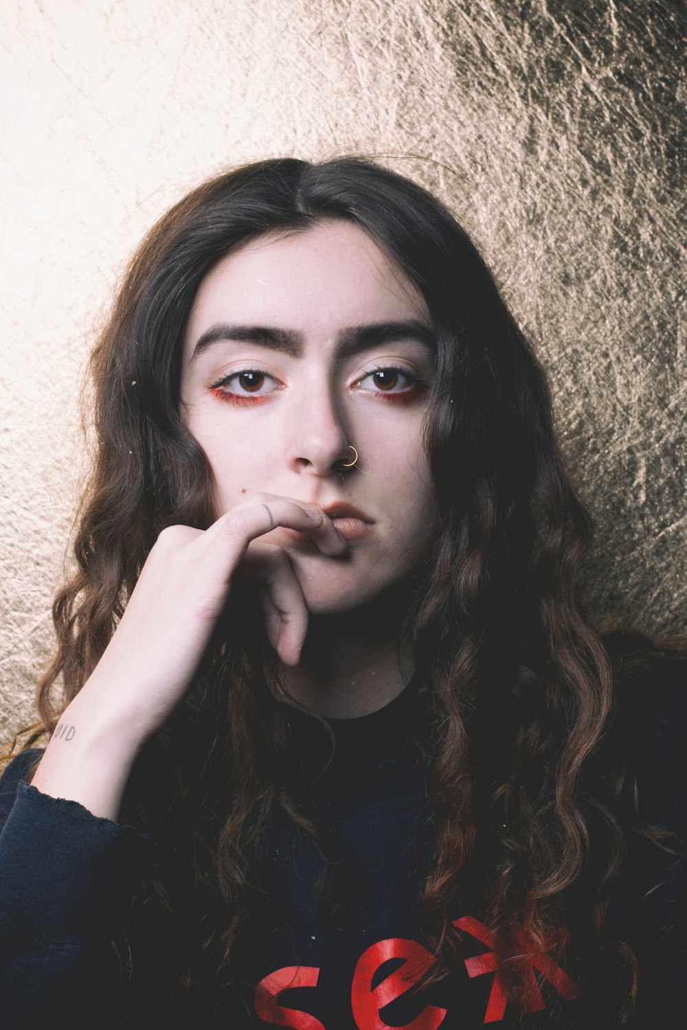 woman in blue sweatshirt leaning on wall photo