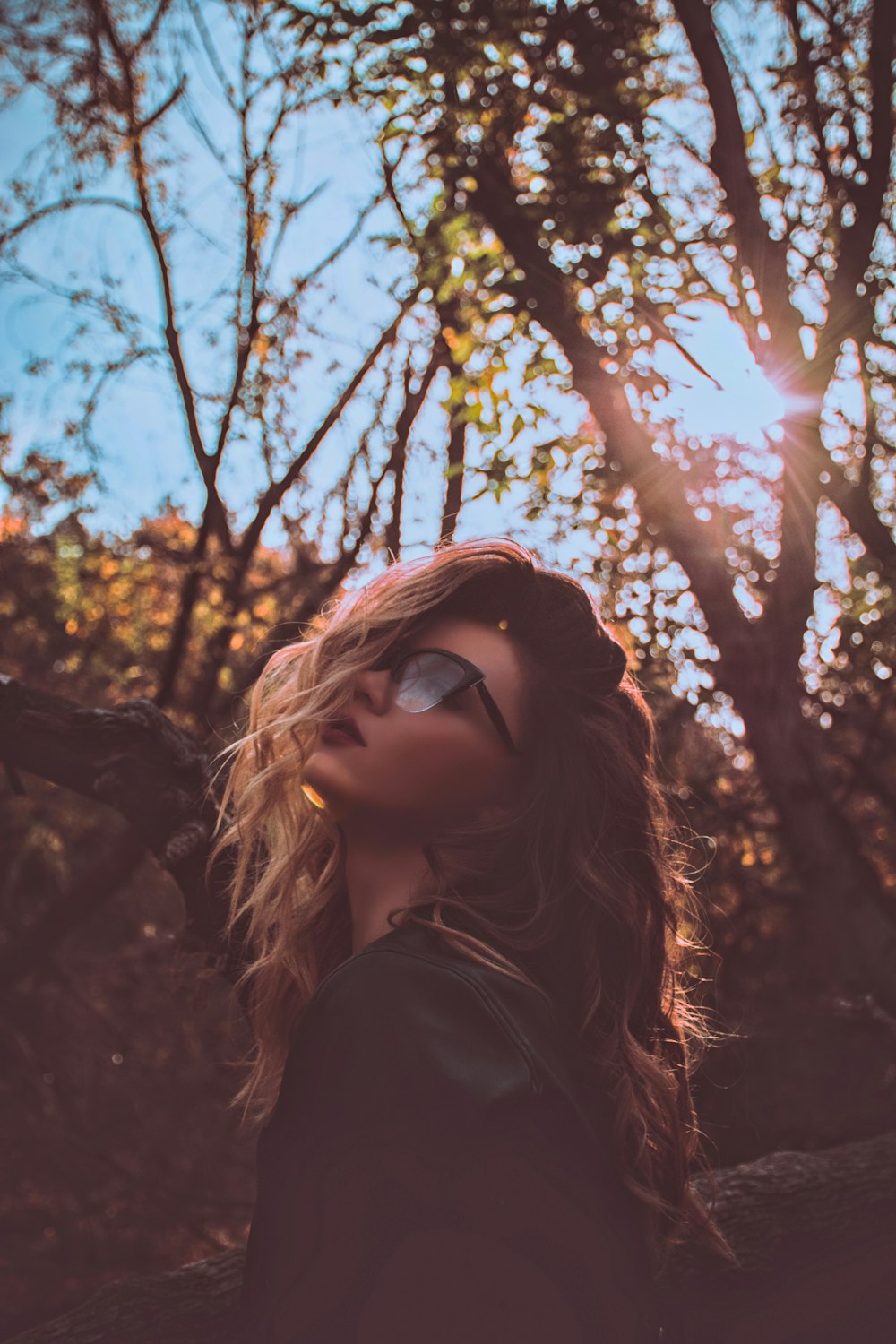 Frau trägt tagsüber Sonnenbrille in der Nähe von Bäumen
