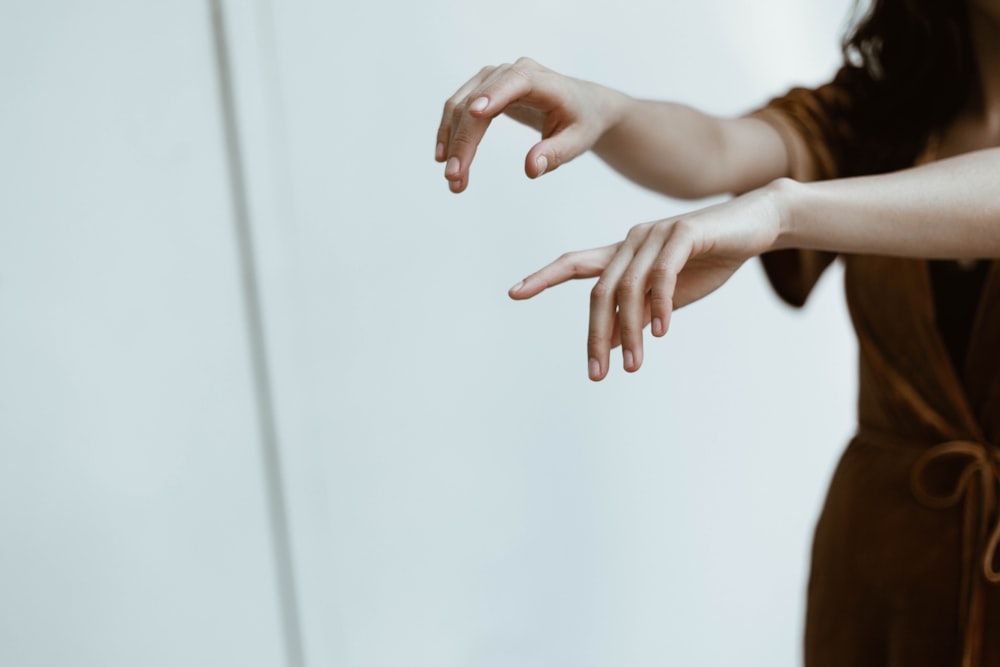 deux personnes debout tout en levant les mains à l’intérieur de la salle peinte en blanc