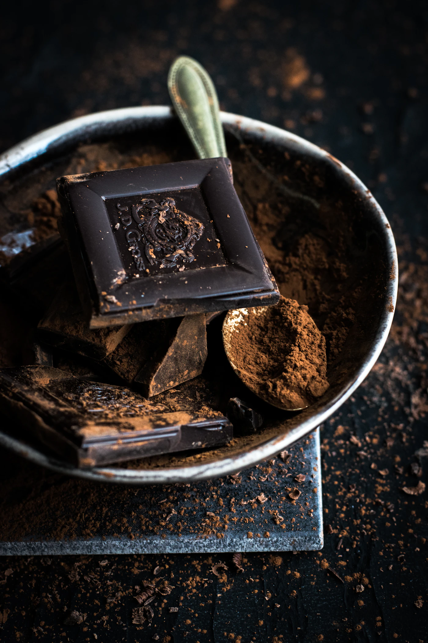 Chocolate bar and cocoa powder being prepared by hand