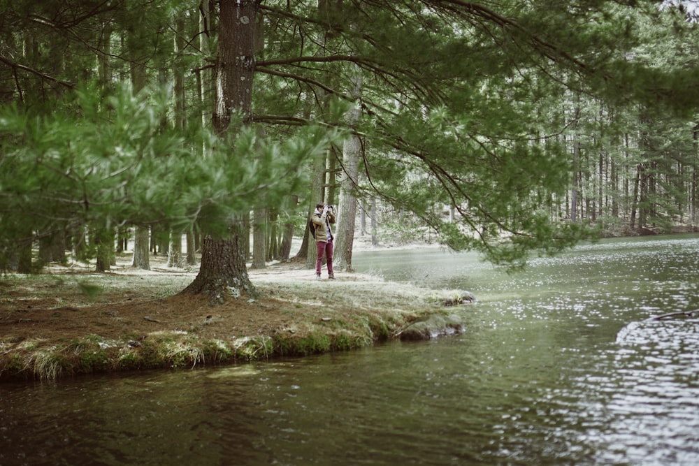 a man and a woman standing next to a river