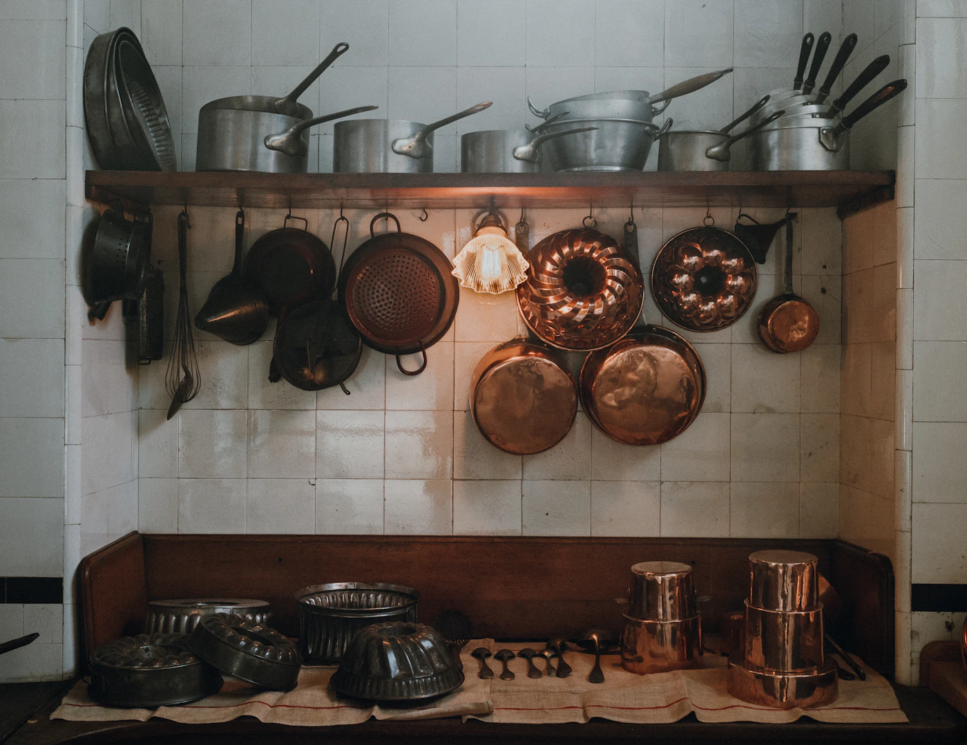 Assorted cookware set hanging in a warm vintage kitchen