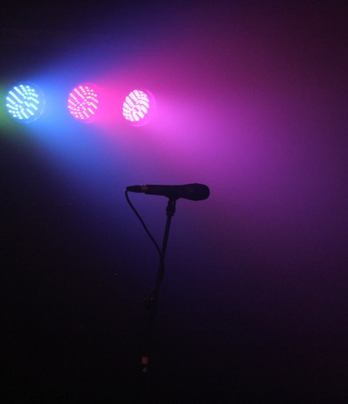 man playing guitar in front of microphone