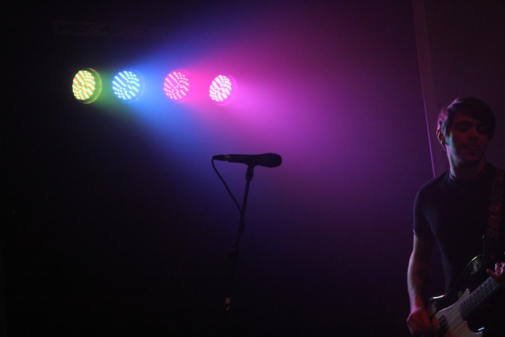 man playing guitar in front of microphone