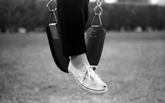 Close-up of colorful flexty sneakers on a playground slide.