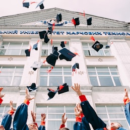 group of fresh graduates students throwing their academic hat in the air