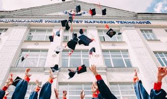 group of fresh graduates students throwing their academic hat in the air