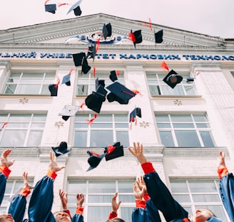 group of fresh graduates students throwing their academic hat in the air