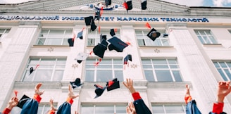 group of fresh graduates students throwing their academic hat in the air