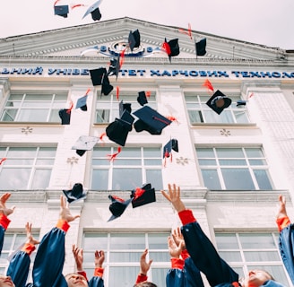 group of fresh graduates students throwing their academic hat in the air