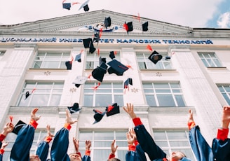 group of fresh graduates students throwing their academic hat in the air