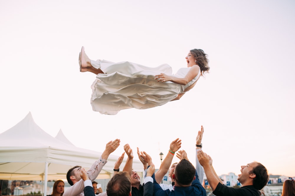 people lifting woman in the air