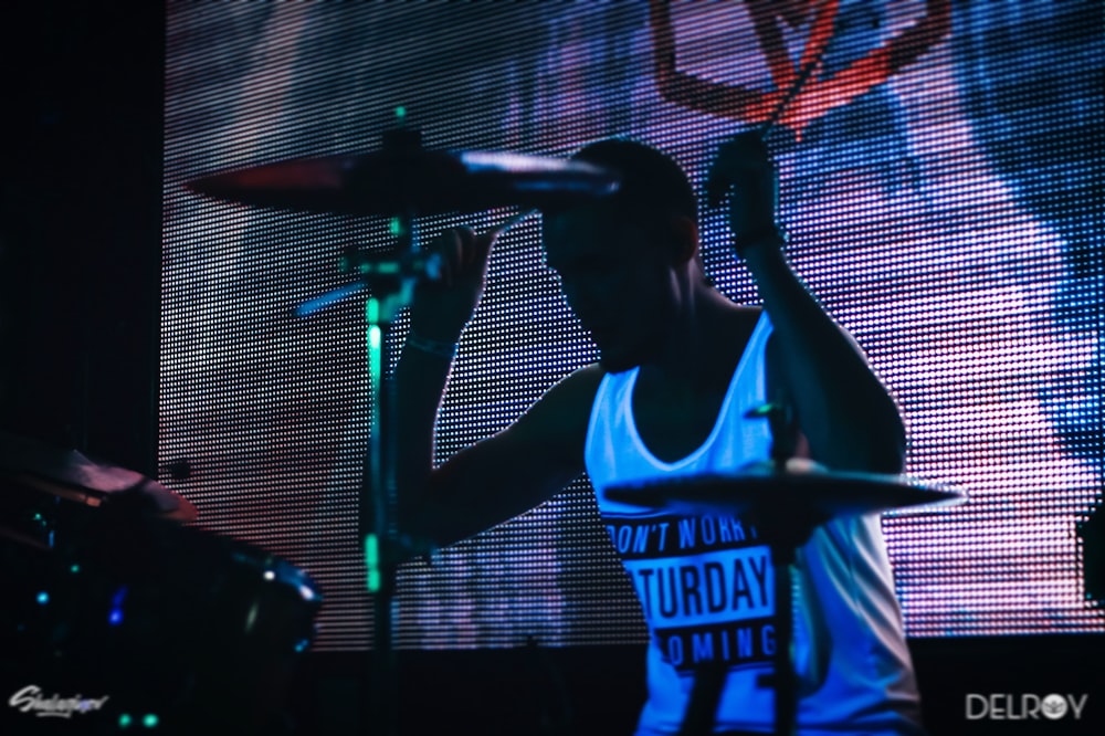 man playing drums infront of monitor