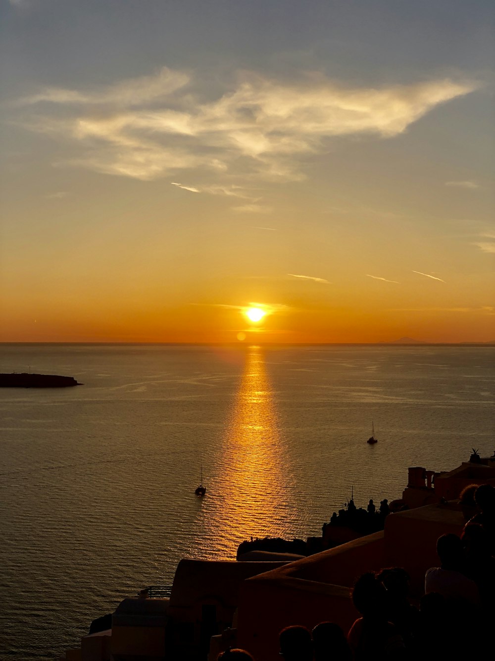 body of water, sailboats, and group of people during sunset