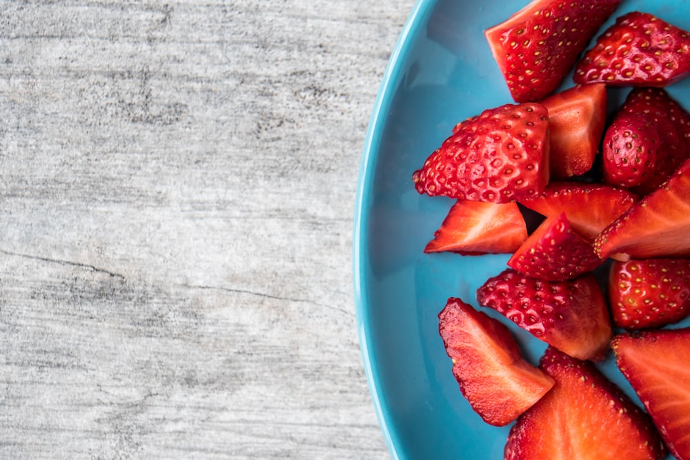 sliced strawberries on teal ceramic plate