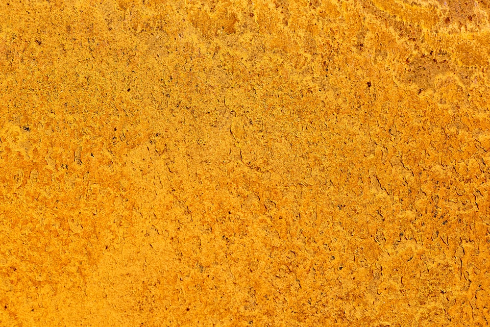 a close up of a yellow surface that looks like dirt