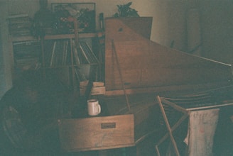 A wide shot of a cozy Parisian apartment filled with electronic music gear and scattered vinyl records.