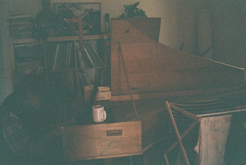 A wide shot of a cozy Parisian apartment filled with electronic music gear and scattered vinyl records.