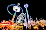 Nighttime scene of the carnival with illuminated costumes and fireworks overhead.