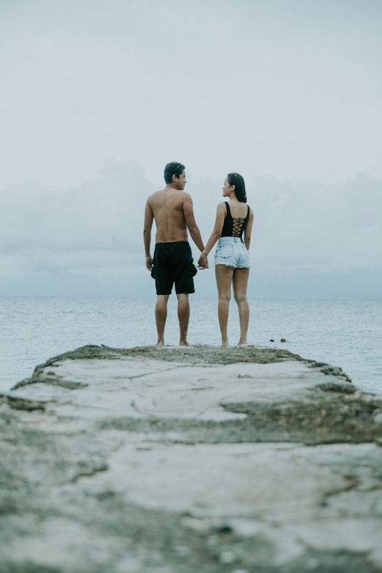 man and woman holding hands standing on edge of cliff in Cebu City Philippines