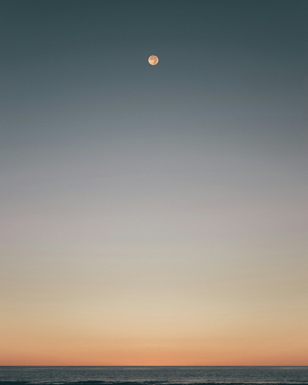 moon over body of water during sunset