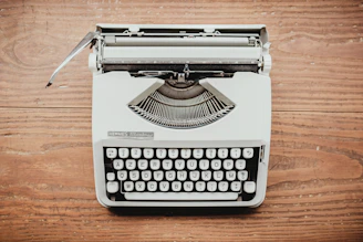white and black typewriter on table