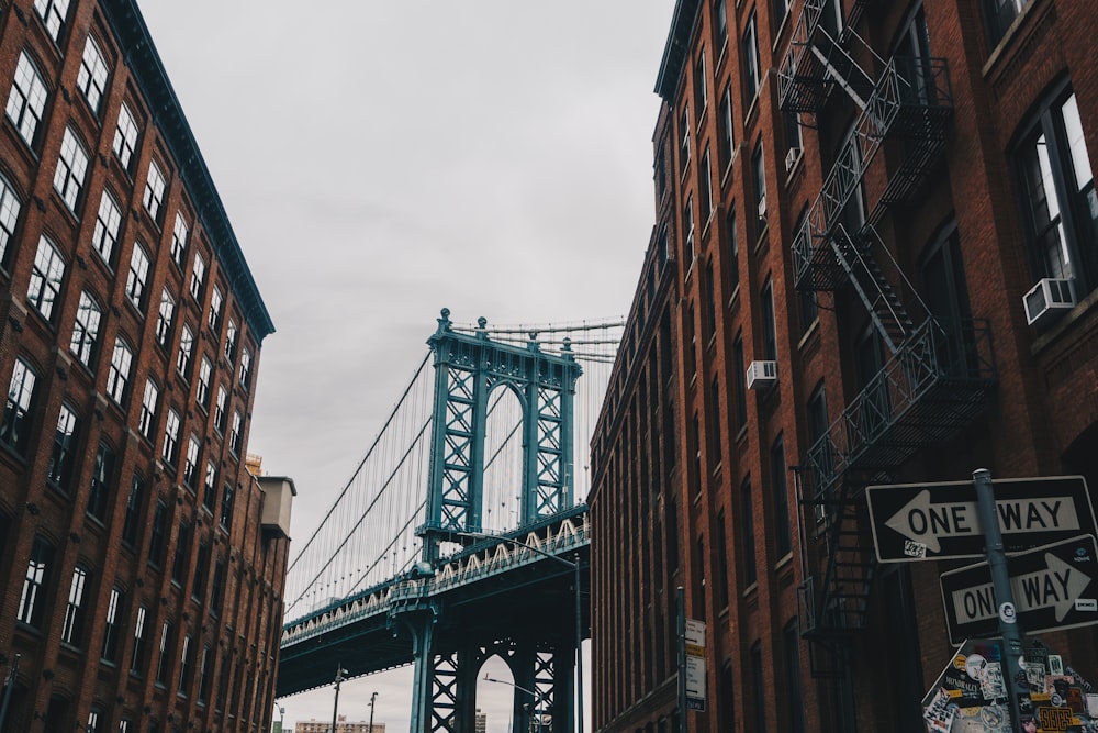 blue bridge between brown building at daytime