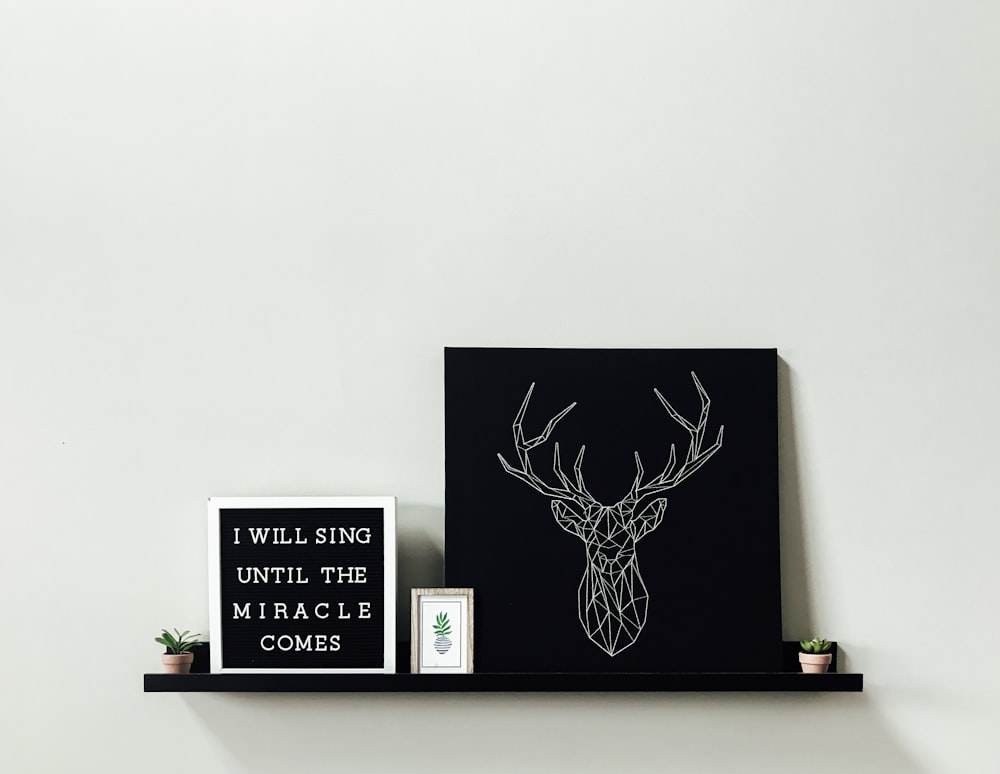white reindeer wall decor on black floating shelf