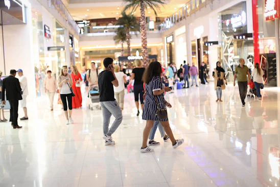 A vibrant highrise pet mall bustling with happy pets and owners exploring various floors filled with unique pet amenities.