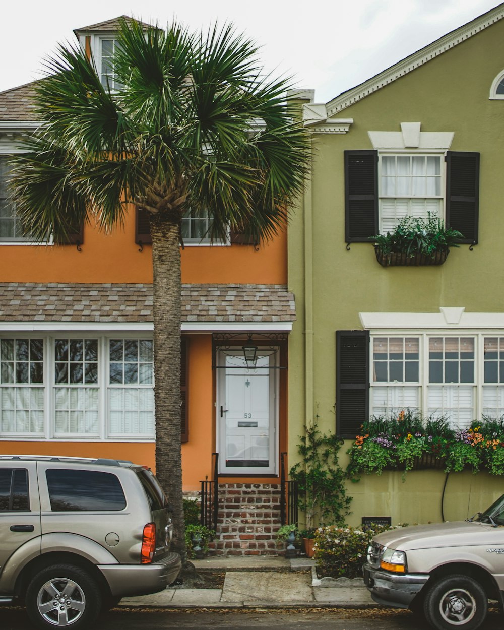 two gray cars parked in front of a house