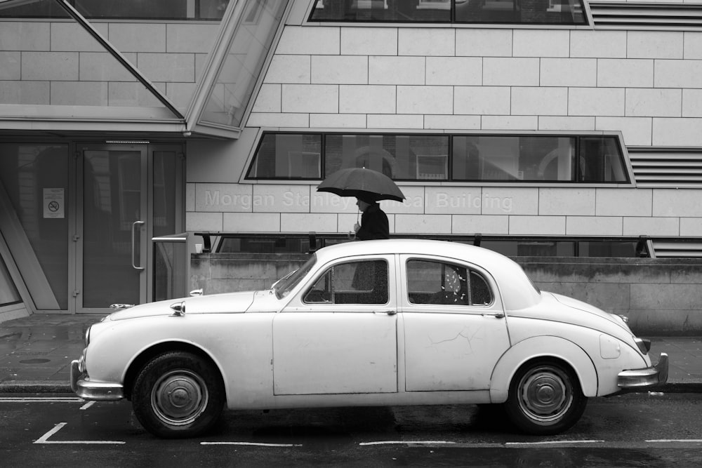 Carro branco vintage estacionado na estrada preta