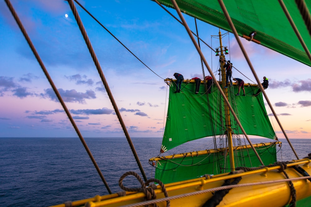 ship with green sail on sea
