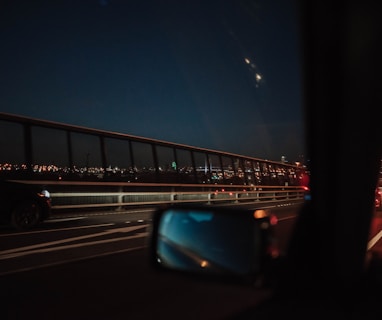 person inside car taking photo on bridge