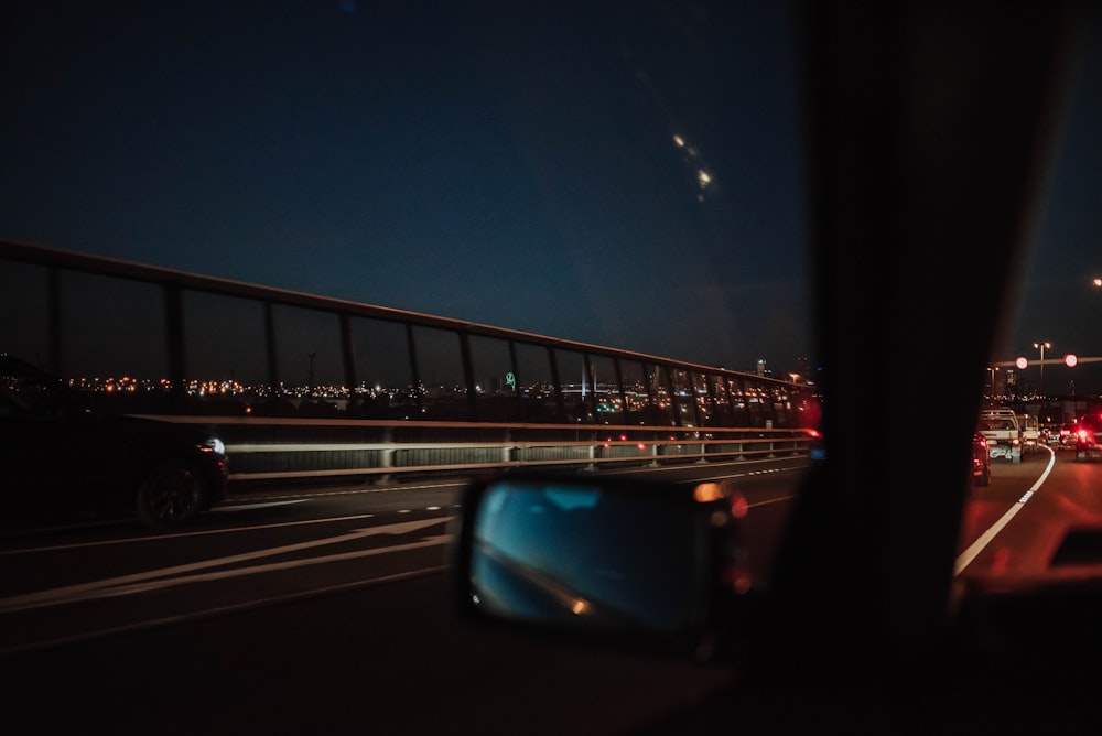 person inside car taking photo on bridge