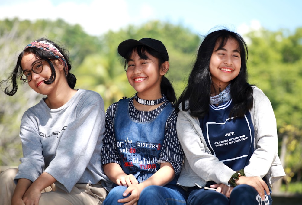 Tres mujeres sentadas cerca de los árboles