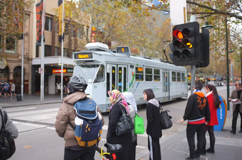 City commuters in business attire waiting at a crosswalk with traffic lights