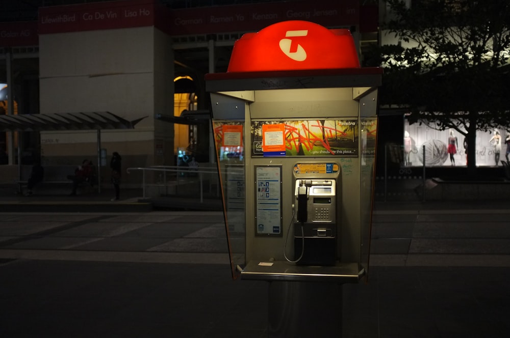 gray and red telephone post on street