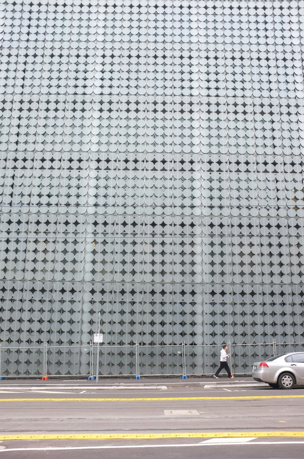 man walking on pathway under glass building