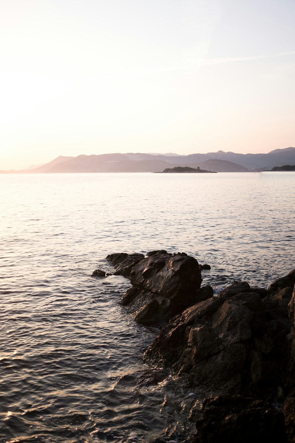 body of water beside stone