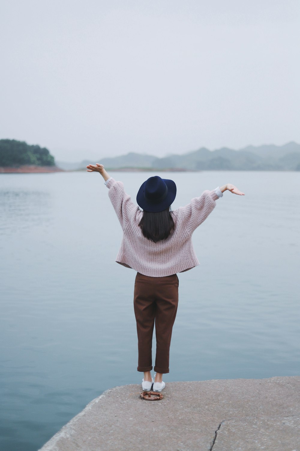 woman standing beside body of water