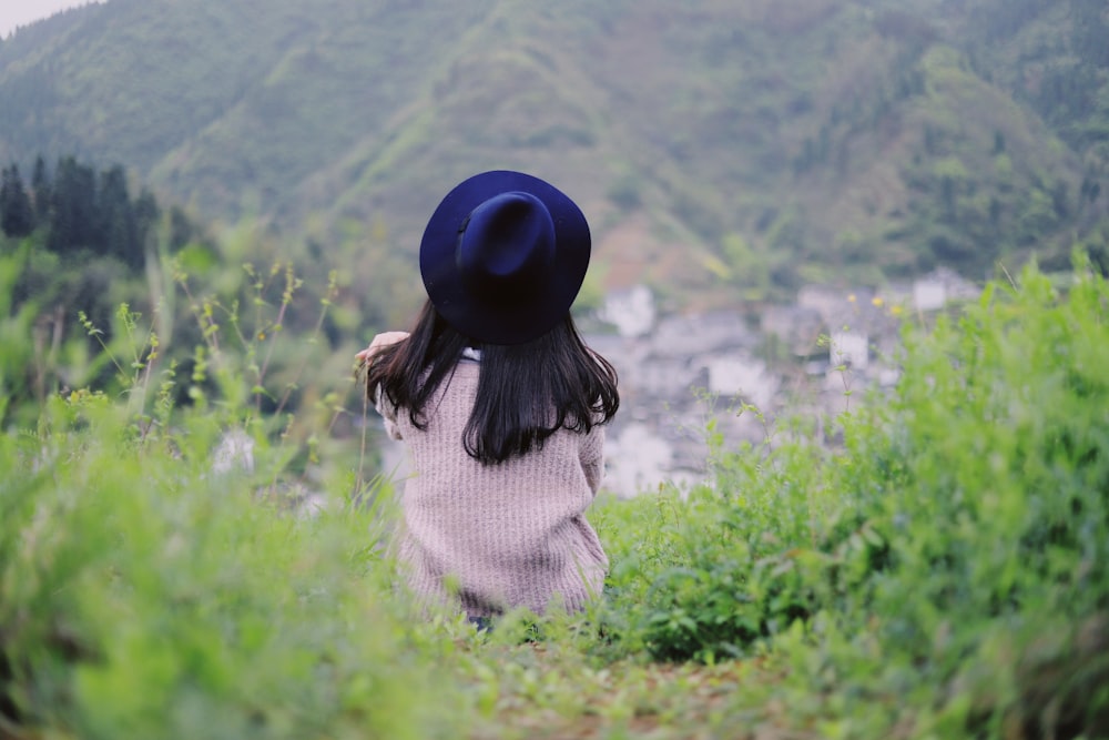 back view of sitting woman on green grass