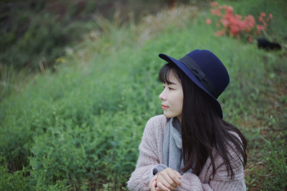 woman wearing blue hat near green grass