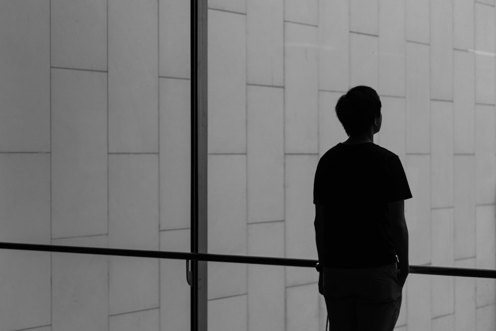 silhouette of a person facing glass wall