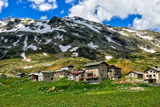 city at the foot of mountain under white clouds and blue sky during daytime in Maloja Pass Switzerland