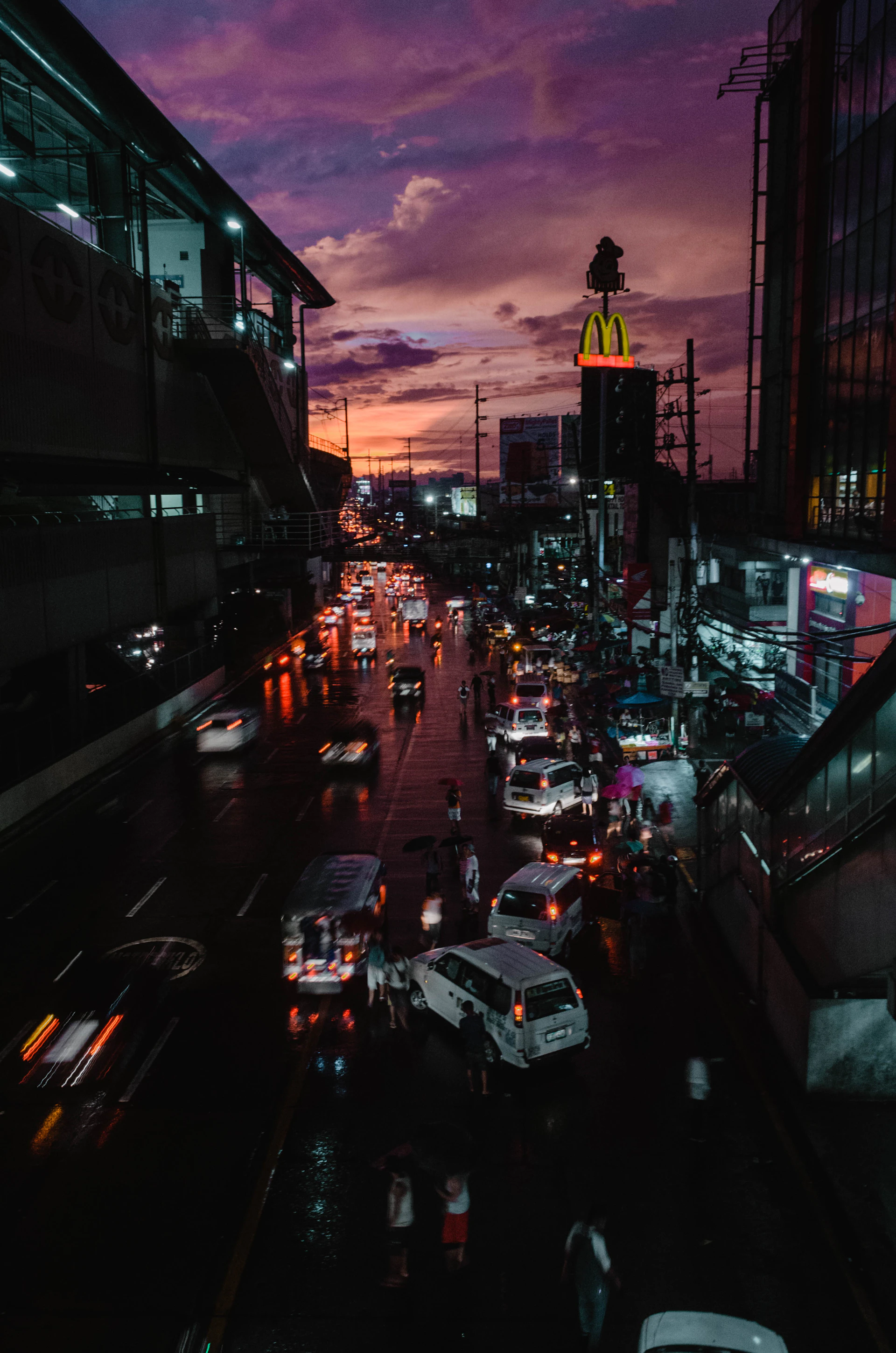 A bustling city street captured at dusk, with vibrant colors and blurred motion showing the energy of urban life.