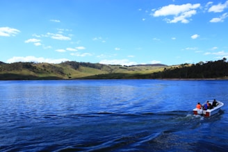 A cheerful family enjoying a boat ride on a sparkling blue lake.