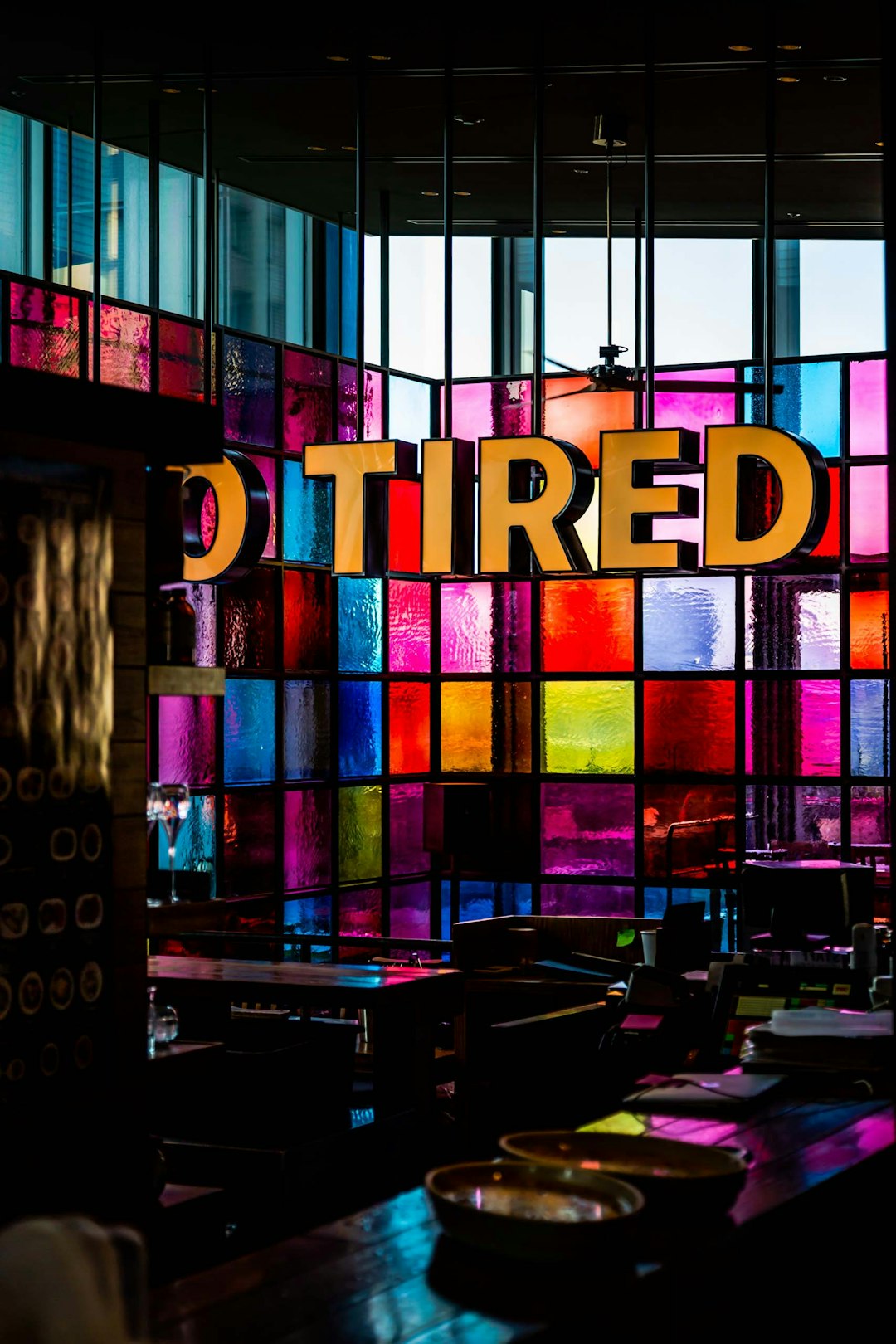 vacant chair and table inside multicolored glass wall